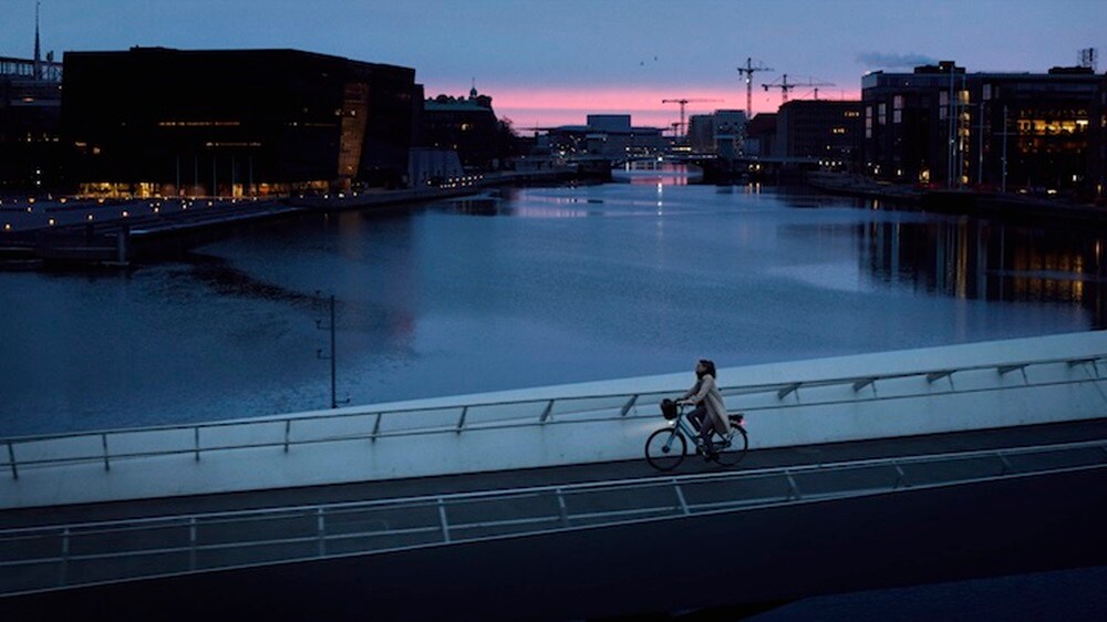 Dame qui fait du vélo sur un pont