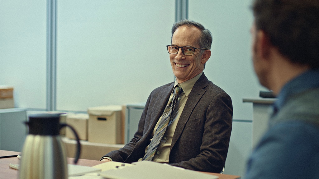 Smiling businessman in a suit and glasses during an office meeting, symbolizing trust and reliability in professional services