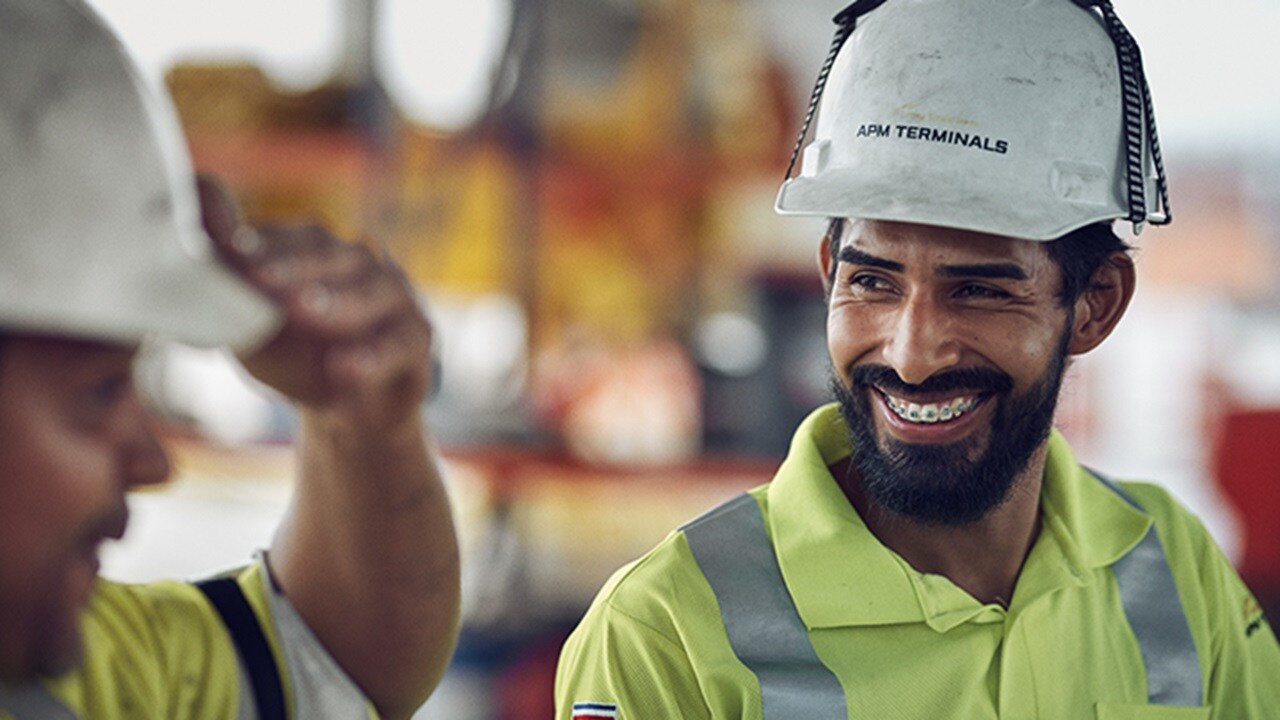 The worker laughs and converses with another person.