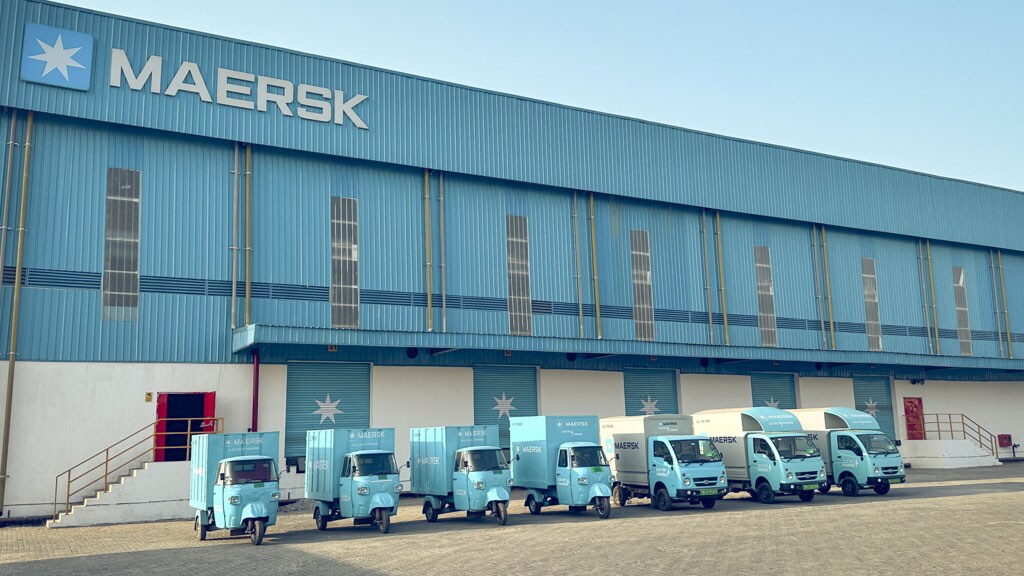 A Maersk storage facility with cargo-carrying trucks in the foreground.