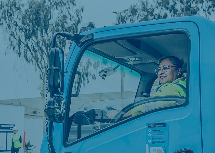 Truck driver seated inside a Maersk vehicle, viewed through the open driver-side window