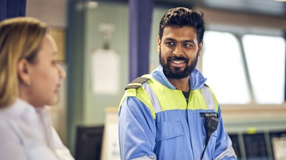 A man in a safety vest talking to a woman