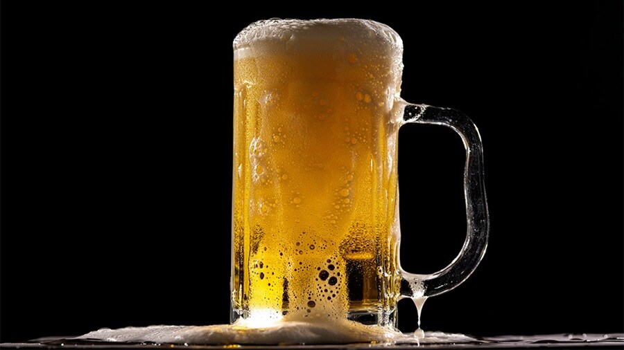 Cold stein of beer resting on a table.