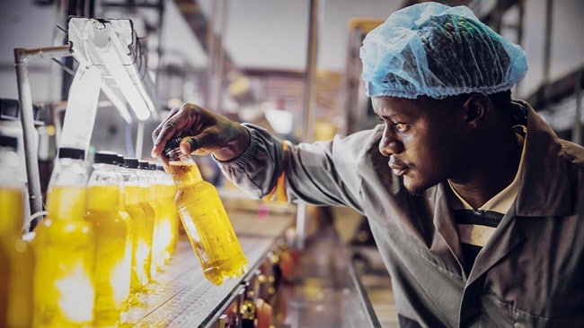 A man in a lab coat operates a complex machine in a laboratory setting.