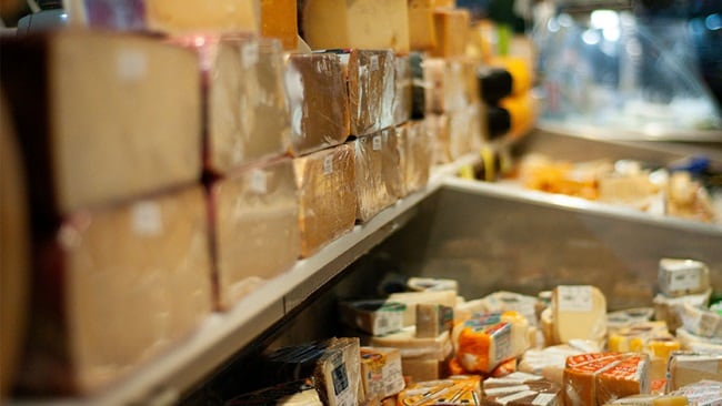 A shelf filled with different types of cheese