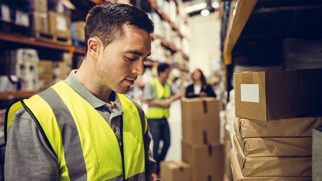 warehouse worker checking barcode on delivery packages