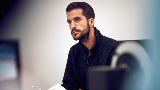 Man working in a procurement office thinking and working.