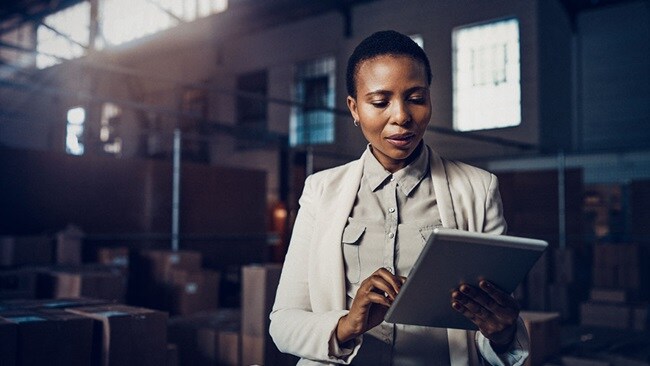 Woman in a warehouse using a tablet in her hand