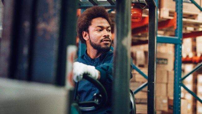 Man driving forklift in warehouse