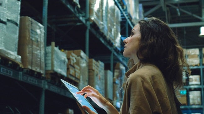 Women with tab checking stock in warehouse