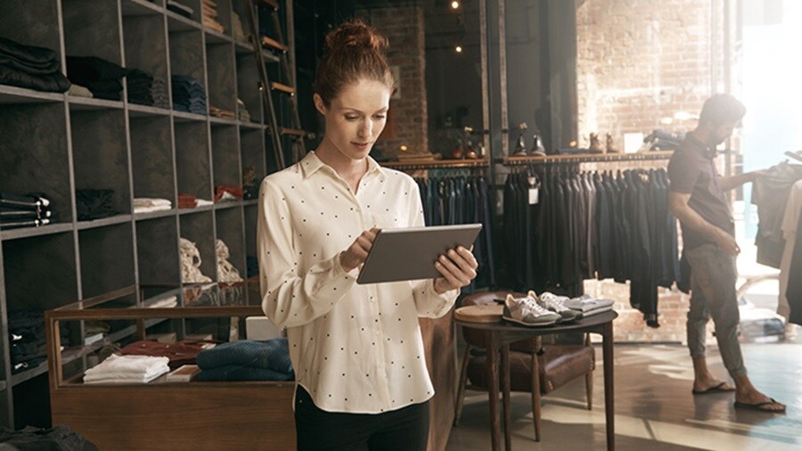 Woman looking at a tablet in a store