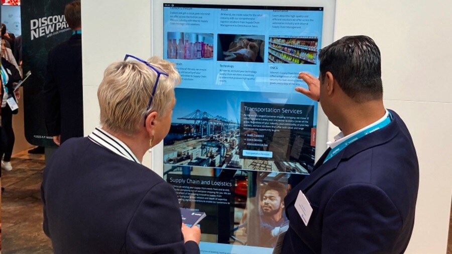 Two man at an event looking at a presentation