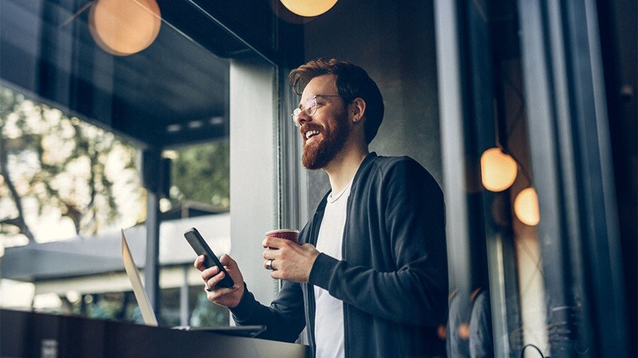 Person in a café holding a smartphone.