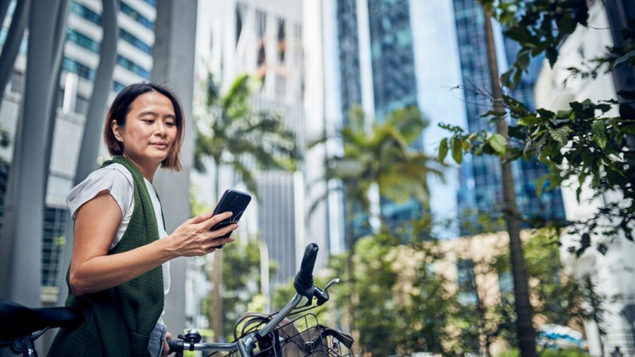 Mujer mirando un teléfono en la ciudad de Singapur 