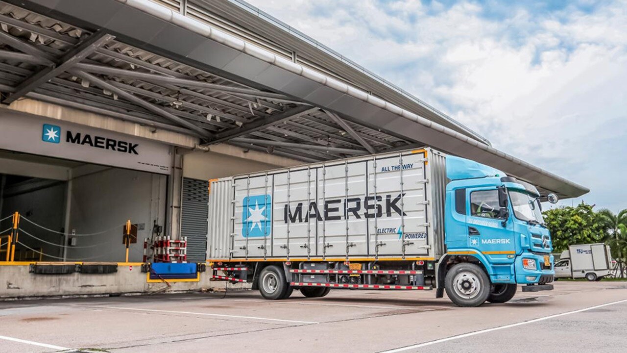 Maersk delivery truck with reefer container parked at a warehouse facility for loading