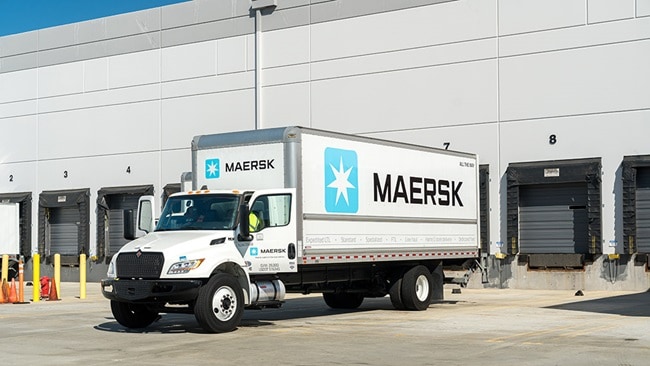 Maersk truck parked at warehouse loading docks for cargo operations