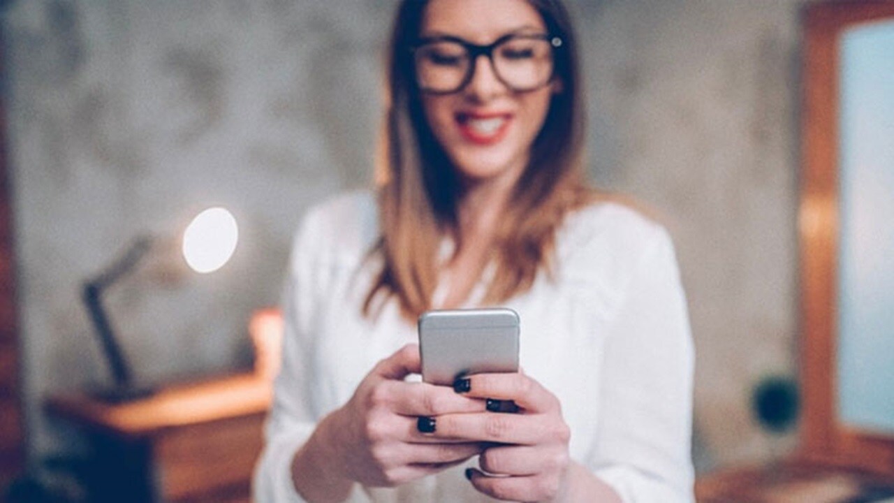 Logistics for D2C marketing – A happy young woman watching something on her mobile.