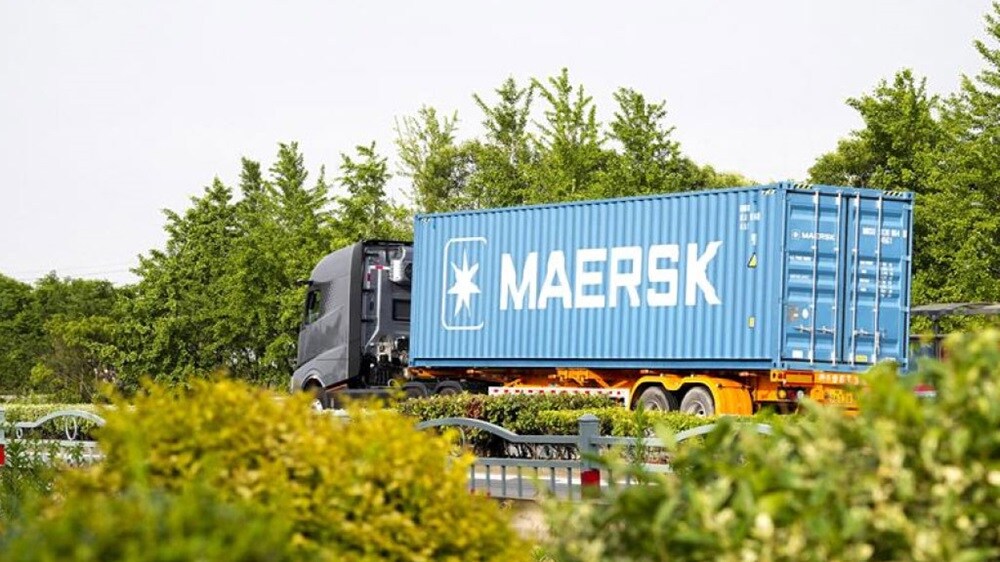 Ein Container-Lkw passiert eine Autobahn.