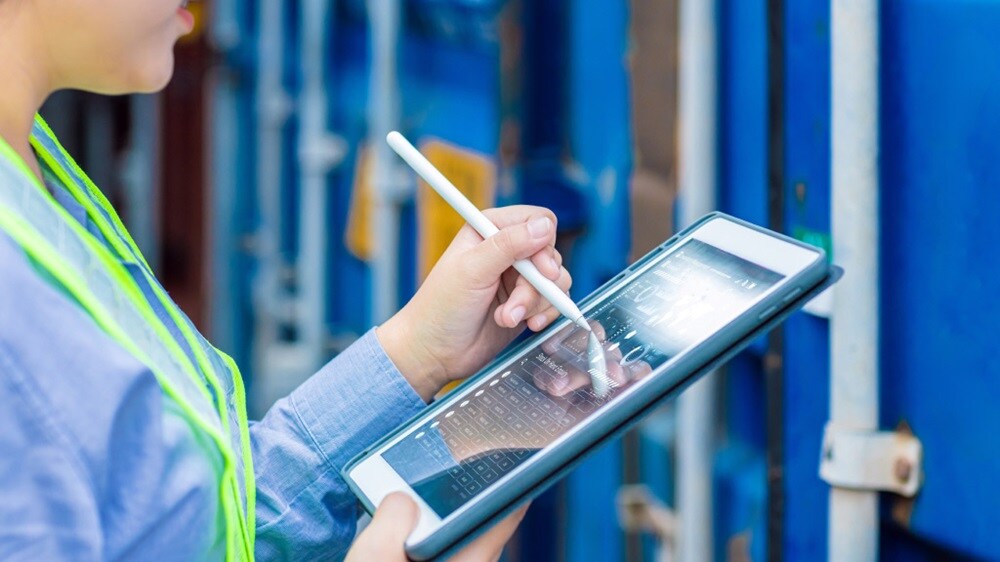 Hafenpersonal kontrolliert Versanddaten auf einem Tablet