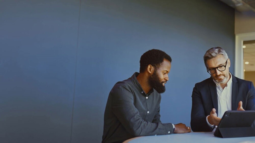 兩位生意人正在使用數位平板電腦討論 ECTN 的要點。