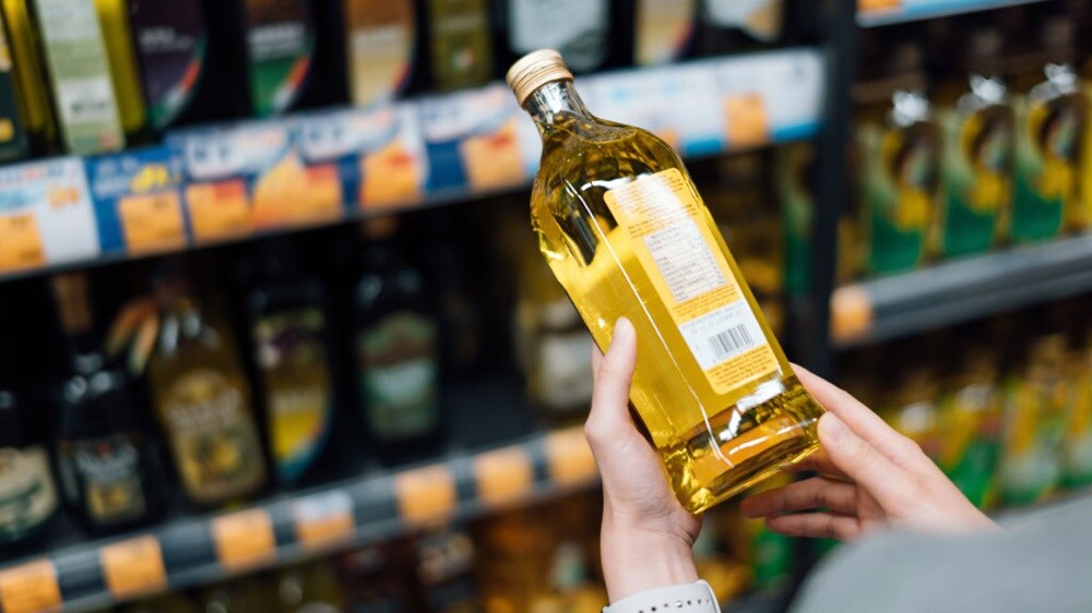 Donna con in mano una bottiglia di olio vegetale
