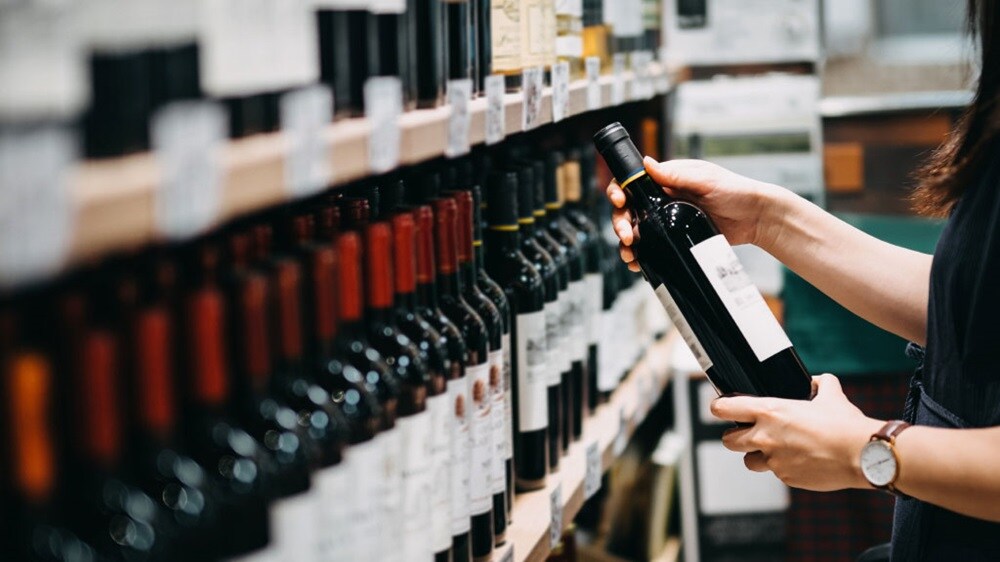 Donna con in mano una bottiglia di vino